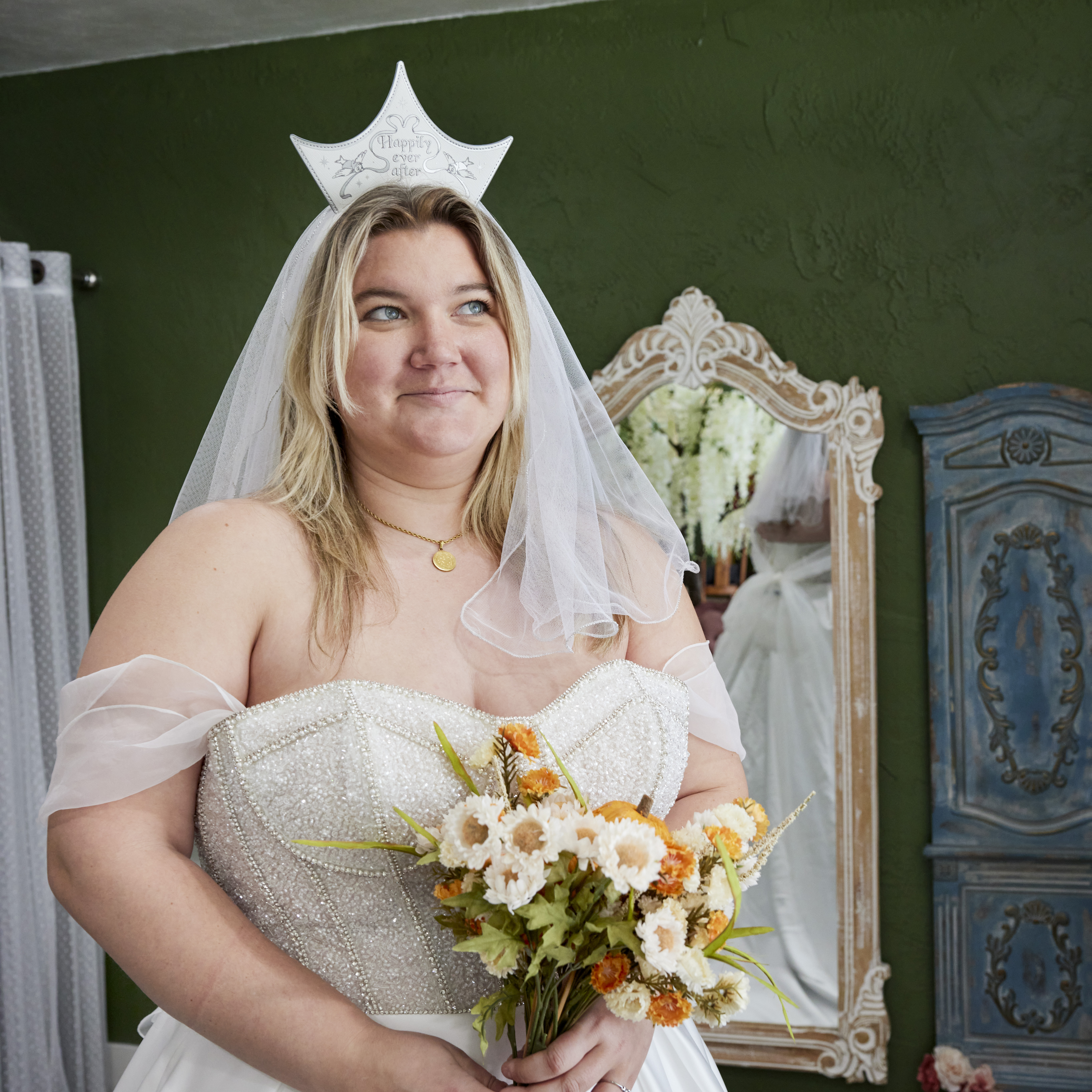 Woman wearing a wedding gown and holding a bouquet and wearing the Cinderella Happily Ever After Headband